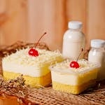 Tempting layered cake topped with cherries and cheese, perfect for dessert lovers.
