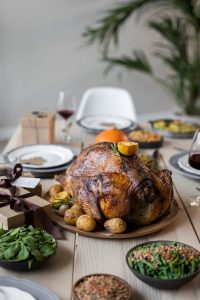 Roasted turkey on a table with side dishes and wine glasses