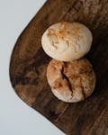 Top-down view of two rustic artisan bread loaves on a wooden board.