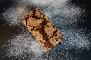 Top view of artisanal multigrain bread with sesame seeds dusted in flour. Perfect for culinary visuals.