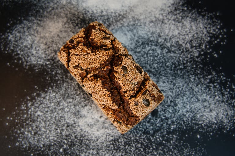 Top view of artisanal multigrain bread with sesame seeds dusted in flour. Perfect for culinary visuals.