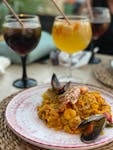 Vibrant seafood paella served with sangria, capturing Spanish flavors in an inviting outdoor setting.